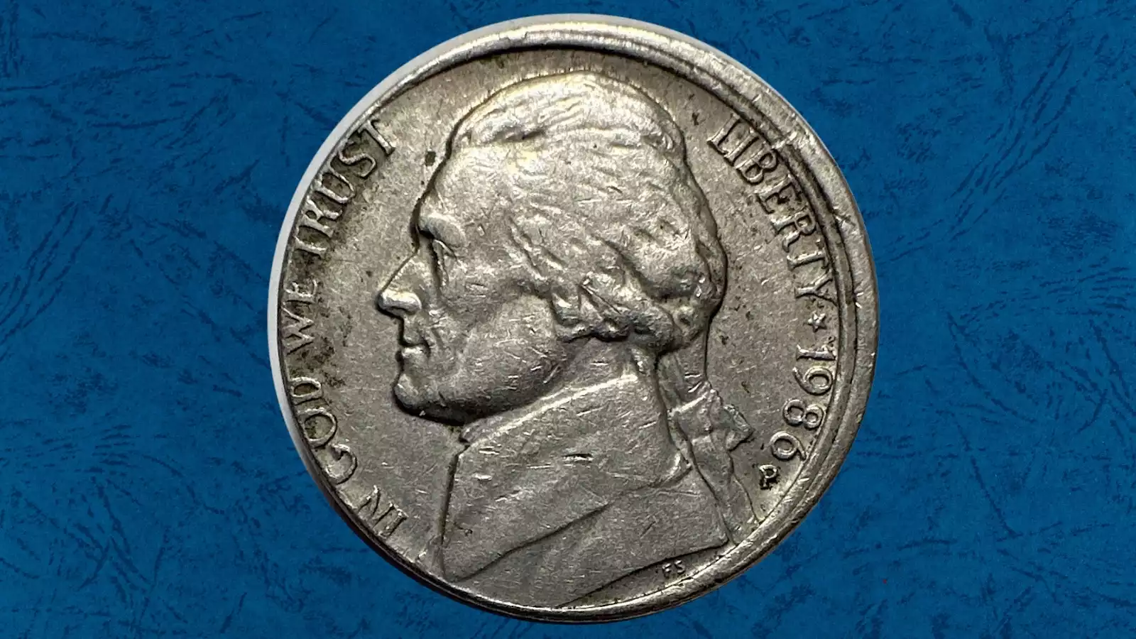 1986-P nickel off-center strike error showing design shifted from center with blank planchet area visible